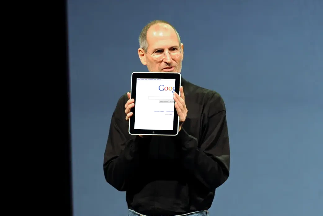Steve Jobs holding an iPad